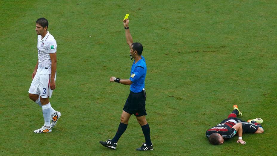 O árbitro, Ravshan Irmatov, do Uzbequistão, mostra o cartão amarelo para Omar Gonzalez, dos Estados Unidos após uma falta sobre Bastian Schweinsteiger, da Alemanha, durante partida na arena Pernambuco, em Recife 