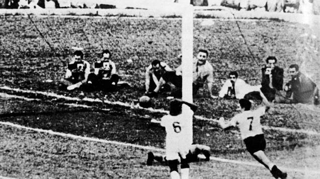 Ghiggia, carrasco do Brasil em 1950, comemora o gol da vitória do Uruguai na final contra o Brasil. Com a bola dentro do gol, Barbosa lamenta no chão