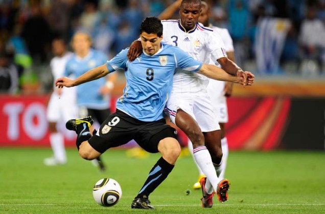 Disputa de bola entre o francês Eric Abidal (direita) e o uruguaio Luis Suarez.