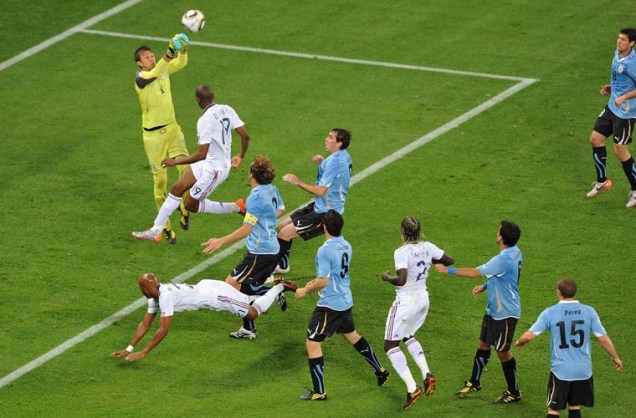 O goleiro do Uruguai, Fernando Muslera, dá um soco na bola.