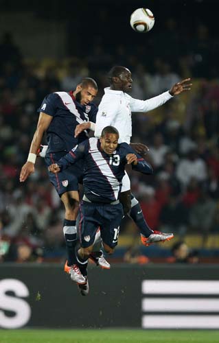 Emile Heskey disputa a bola com dois jogadores americanos, Oguchi Onyewu (esquerda) e Ricardo Clark.