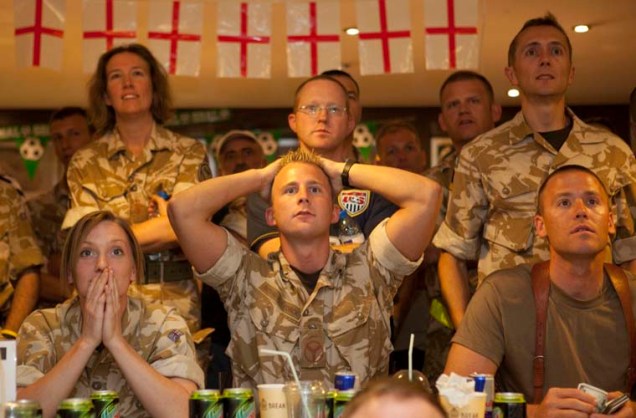 Soldados ingleses e americanos assistem ao jogo entre Inglaterra e Estados Unidos.