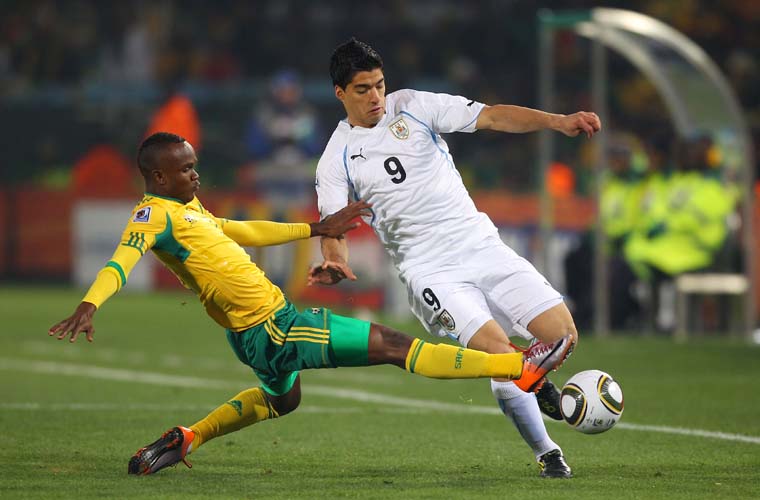 Disputa de bola entre Siboniso Gaxa, da África do Sul e Luis Suarez, do Uruguai.