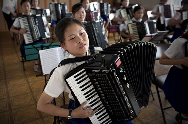 Crianças em aula de acordeão numa escola na capital.
