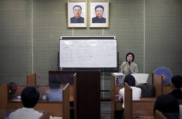 Aula de inglês numa escola de línguas estrangeiras. Na parede, as fotos do presidente Kim Il-sung (à dir.) e Kim Jong-Il