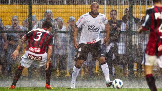 Debaixo de chuva, Fabricio, do Altlético/PR, tenta marcar o corinthiano Adriano, em partida pelo Campeonato Brasileiro - 13/11/2011