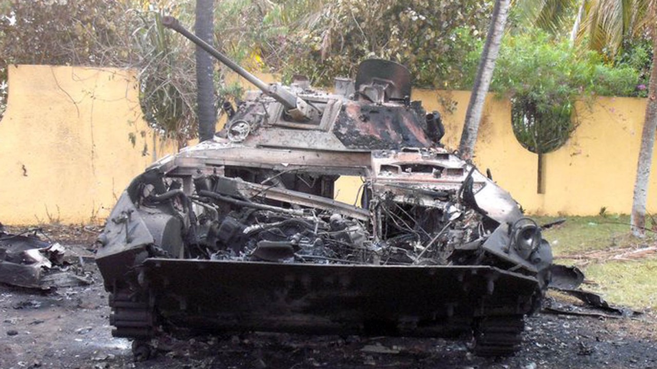 Tanque das forças pró-Gbagbo atingido por um míssil antitanque das forças francesas durante resgate de embaixador e diplomatas japoneses