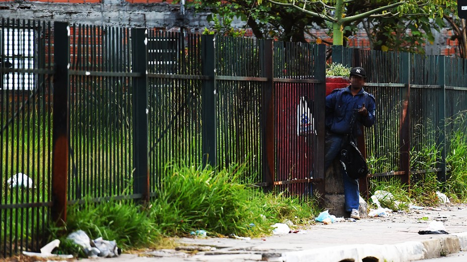 Homem passa entre grades do Piscinão Guaraú, local usado por viciados em crack na Av. Gal. Penha Brasil, em São Paulo