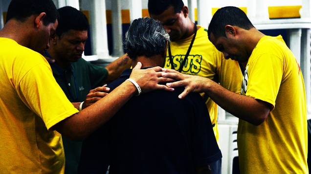 Voluntários da Missão Cristolândia rezam junto com usuário
