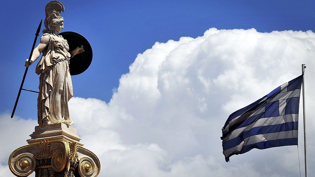 Bandeira tremula ao lado de estátua da deusa Atenas, patrona da capital homônima da Grécia