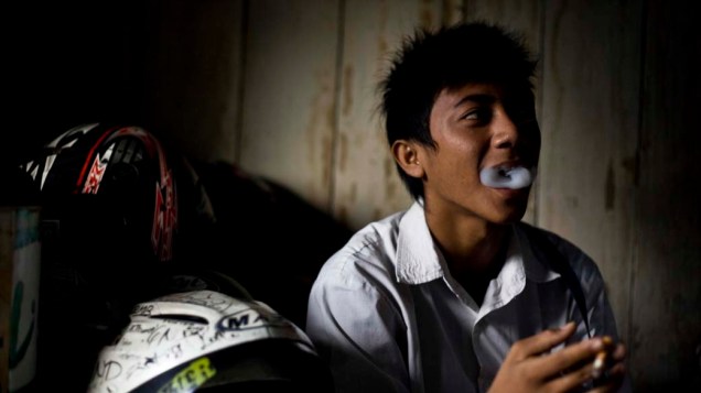 Estudante fuma antes de ir para a escola em Yogyakarta, Indonésia