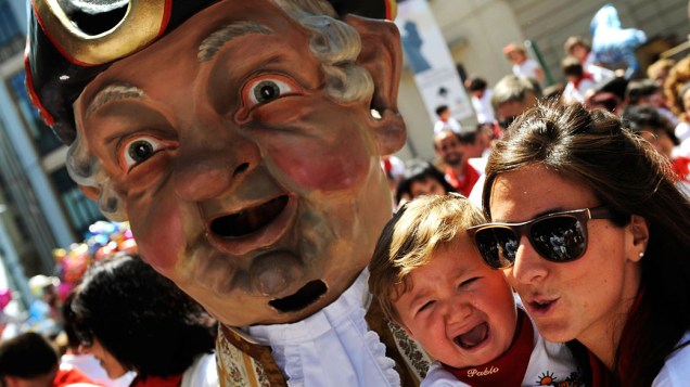 "Kiliki", personagem do desfile de gigantes e cabeças grandes, deixa criança assustada durante festival de São Firmino, em Pamplona, Espanha