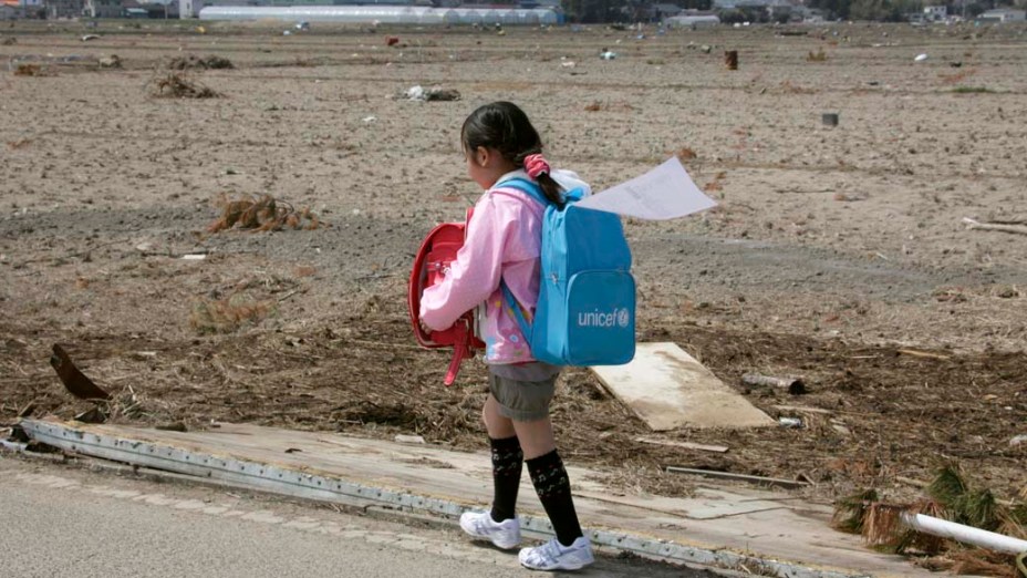 Na cidade de Natori, criança volta para casa após seu primeiro dia de aula desde o terremoto e tsunami que destruiram a região