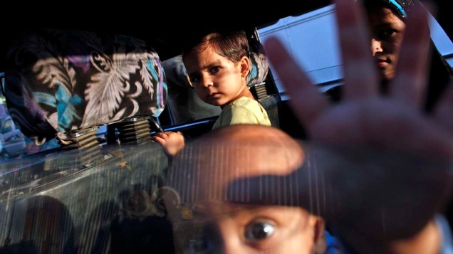 Crianças aguardam por família dentro de táxi em Mumbai, Índia