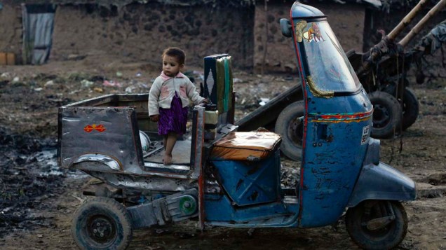 Criança brinca em riquexá, no Paquistão