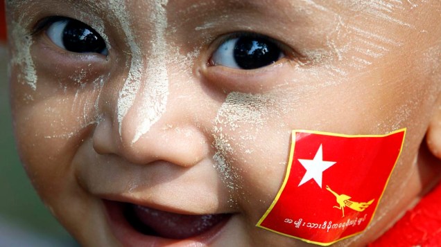 Criança com a bandeira da Liga da Oposição Nacional para a Democracia (NLD), durante campanha eleitoral em Mianmar