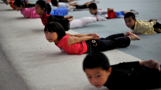 Crianças se alongam durante aula de ginástica em Qingdao, China