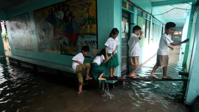 Na capital Manila, estudantes filipinos em escola alagada após a tempestade tropical que atingiu a região nos últimos dias