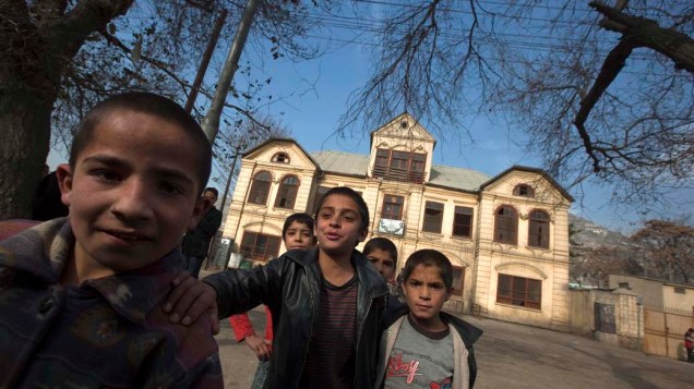 Crianças brincam em frente a escola em Cabul, no Afeganistão