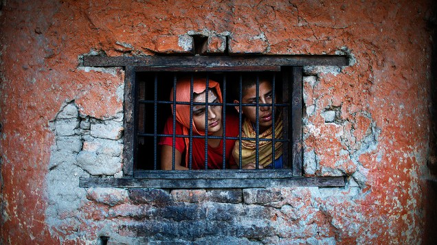Estudantes de escola hindu olham para fora da janela da sala de aula em Katmandu, no Nepal