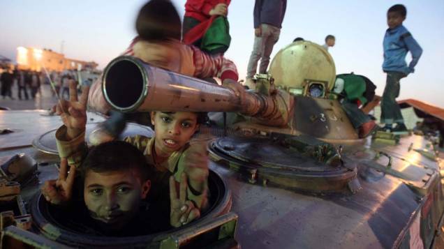 Crianças em um tanque de guerra destuído em Bengasi, Líbia