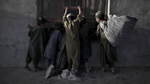 Crianças esperam pagamento ao final de seu dia de trabalho no Afeganistão