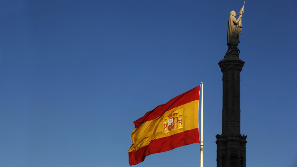 A bandeira da Espanha e a estatua de Colombo em Madri