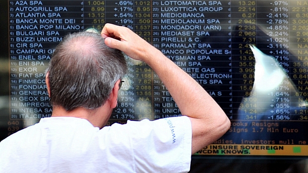 Pedestre observa tela com resultados da Bolsa de Milão nesta segunda-feira