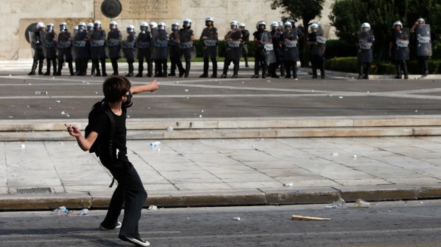 Manifestante enfrenta policias durante protesto em Atenas, Grécia
