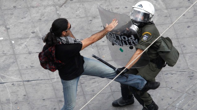 Policial e manifestante durante protesto em Atenas, Grécia