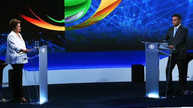 Os dois candidatos à Presidência, Aécio Neves (PSDB) e Dilma Rousseff (PT), participam do primeiro debate do segundo turno promovido pela Rede Bandeirantes, na noite desta terça-feira (14)