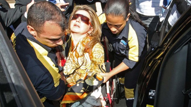 A promotora Deborah Guerner deixa o serviço médico do TRF de cadeira de rodas, acompanhada de dois brigadistas, após passar mal durante julgamento no Tribunal Regional Federal da 1ª Região, em Brasília