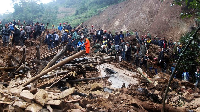Equipes de resgate trabalham para resgatar o corpo de mais duas vítimas do deslizamento de terra que cobriu de escombros uma escola primária e casas na província chinesa de Yunnan, no sudoeste do país