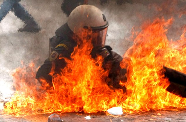 Policial é atingindo por um coquetel molotov em manifestação organizada por funcionários públicos em Atenas, na Grécia, na quarta-feira. Três pessoas morreram no confronto. As greves são uma reação ao anúncio do pacote de austeridade fiscal definido pela União Europeia e pelo Fundo Monetário Internacional (FMI), no último domingo.