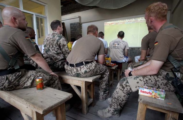Soldados alemães assistem à primeira partida da Copa do Mundo em Taloqan, no Afeganistão.