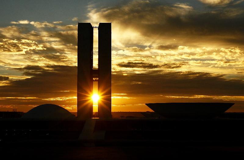O sol surge entre as duas torres do Congresso Nacional no 50° aniversário da cidade de Brasília.