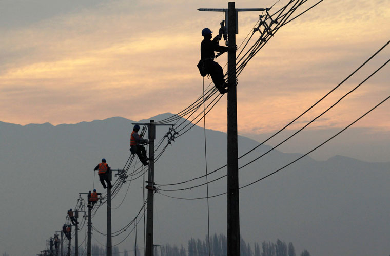 Trabalhadores fazem reparos em postes de energia de uma área rural próxima a Santiago. A rede elétrica ficou seriamente danificada por conta do terremoto que atingiu o Chile em fevereiro deste ano, deixando mais de 700 pessoas mortas.