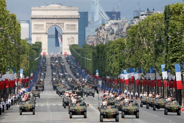 Veículos blindados circulam pela avenida Champs-Élysées durante o Dia da Bastilha, em Paris.