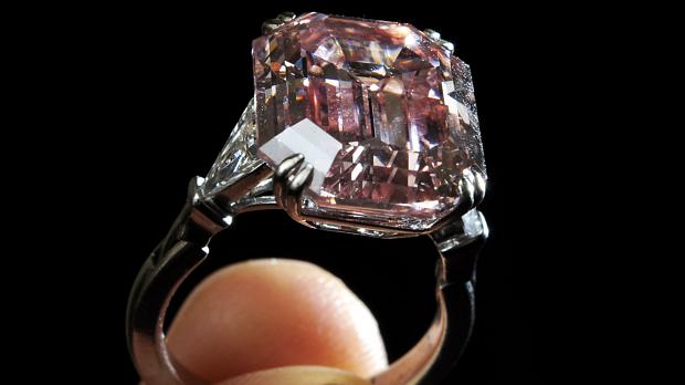SWITZERLAND, Geneva : A pink diamond ring weighing 10.99 carats is held by a model during a Sotheby's auction press preview on May 11, 2011 in Geneva. The stone, mounted as a ring has been graded "fancy intense pink". Pink diamonds have been prized for their rarity, and have extraordinary optical transparency. It is expected to sell between GBP 5.4-9.6m (dollars 9-16m or euros 6-10.8m) when it is auctioned at the Magnificent and Noble Jewels in Geneva on May 17. AFP PHOTO / FABRICE COFFRINI