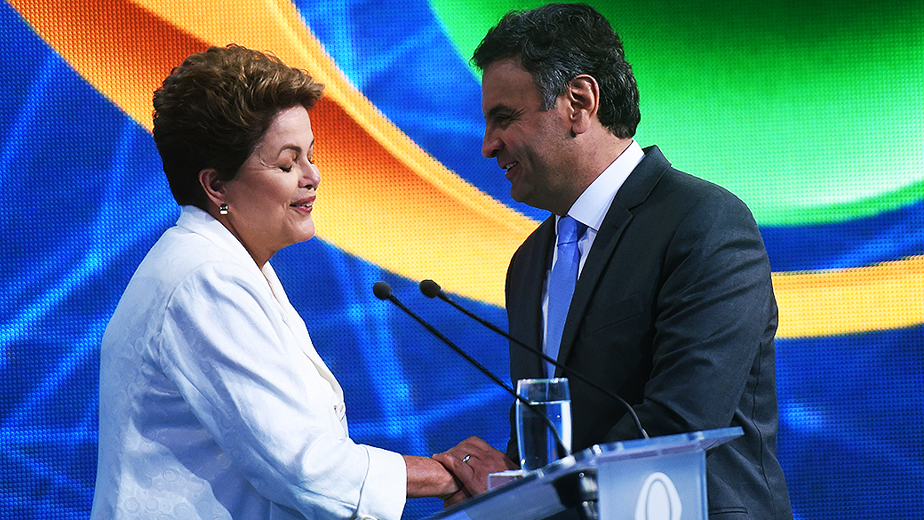 Os dois candidatos à Presidência, Aécio Neves (PSDB) e Dilma Rousseff (PT), participam do primeiro debate do segundo turno promovido pela Rede Bandeirantes, na noite desta terça-feira (14)