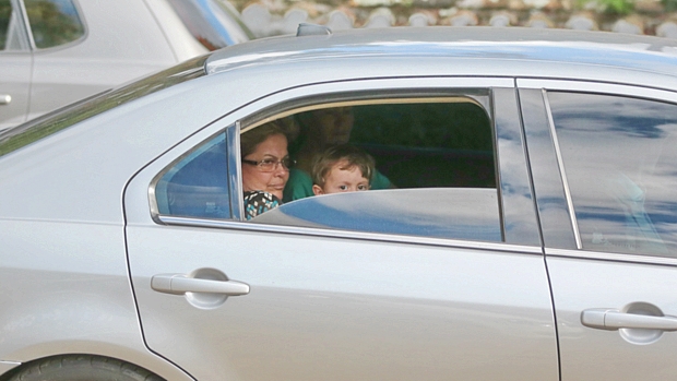 Dilma carrega o neto no colo no banco de trás do carro