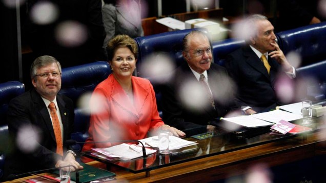 Em Brasília, a presidente Dilma olha para pétalas de flores jogadas durante sessão no congresso para apresentar o "Diploma de Mulher Cidadã Bertha Lutz", que honrará mulheres que lutaram pela igualdade entre sexos
