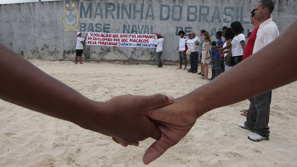 Integrantes da comunidade do Quilombo dos Macacos de Salvador protestam em frente ao muro da Base Naval de Aratu