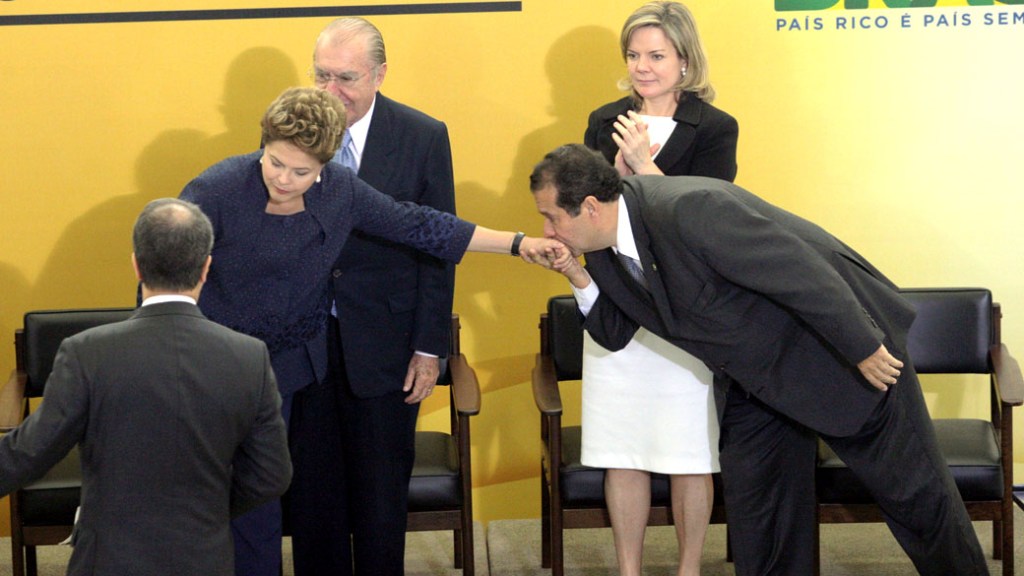 O Ministro do Trabalho Carlos Lupi beija a mão da presidente Dilma Rousseff na cerimônia de sanção da lei que cria o Programa Nacional de Acesso ao Ensino Técnico e ao Emprego (Pronatec) no Palácio do Planalto, em Brasília
