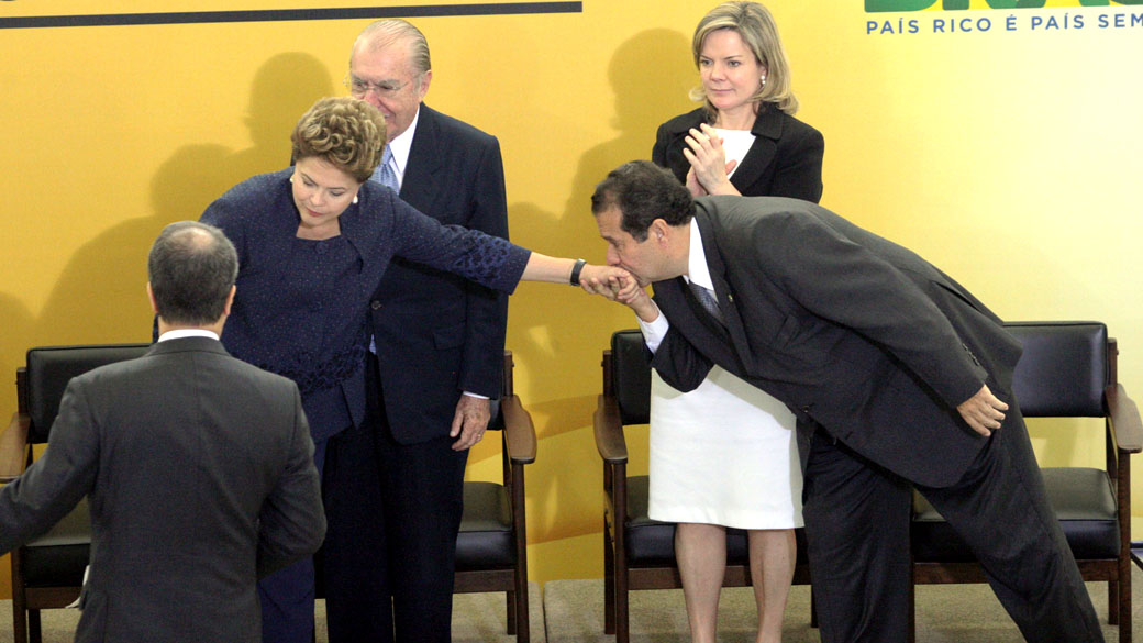 O Ministro do Trabalho Carlos Lupi beija a mão da presidente Dilma Rousseff na cerimônia de sanção da lei que cria o Programa Nacional de Acesso ao Ensino Técnico e ao Emprego (Pronatec) no Palácio do Planalto, em Brasília