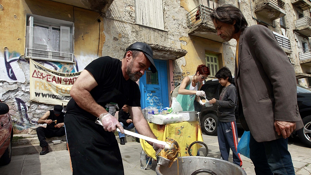 O grego Constantinos Polychronopoulos, 47, analista de marketing desempregado, distribui sopa aos mais pobres nas ruas de Atenas