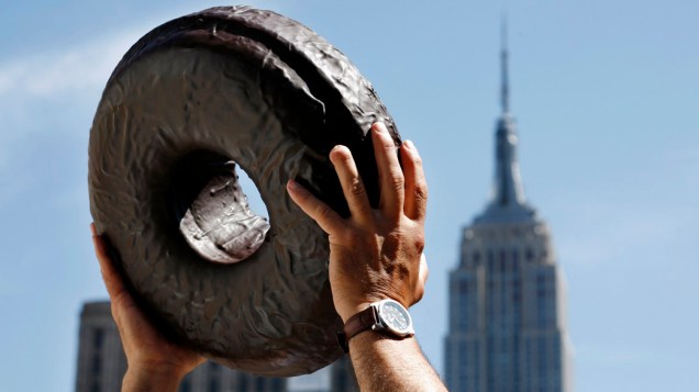 Americano segura um Donut gigante no 75º Dia Nacional do Donut, em Nova York Americano segura um Donut gigante no 75º Dia Nacional do Donut, em Nova York