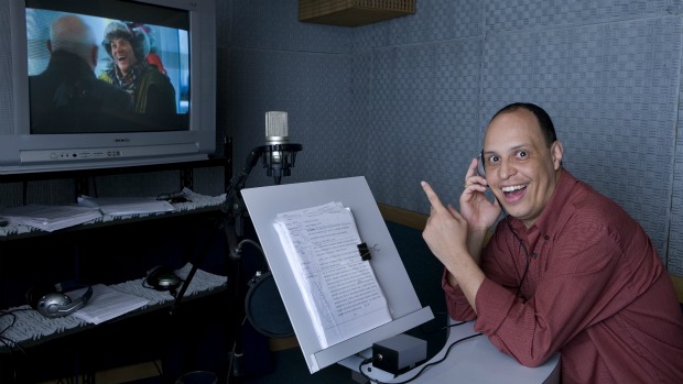 O dublador Marco Ribeiro em estúdio, com Jim Carrey no monitor: ele é a voz do ator na versão brasileira de 'Os Pinguins do Papai'