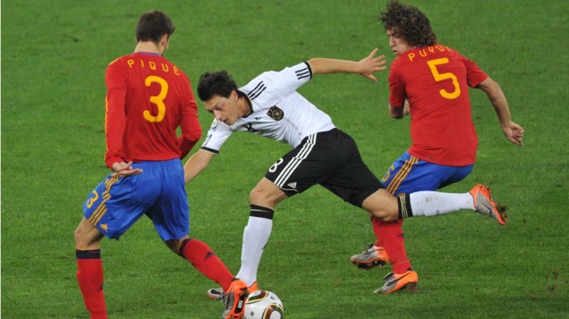 Mesut Oezil tenta sair da defesa espanhola durante a partida Alemanha e Espanha pela Semifinal da Copa da África do Sul