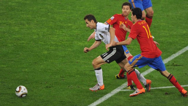 Miroslav Klose tenta sair da defesa espanhola durante a partida Alemanha e Espanha pela Semifinal da Copa da África do Sul
